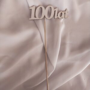 Napis drewniany na piku "100 lat" bielone
